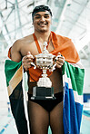 Sports man, trophy and flag for South Africa, pride and portrait for success by pool, competition and challenge. Swimming athlete, champion and winner with celebration, goals and fabric with smile