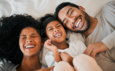 Buy stock photo Top view, home and family with a smile, love and bedroom with weekend break, relax and laughing together. Happy parents, mother or father with child, bed and kid with humor, joke and resting with joy