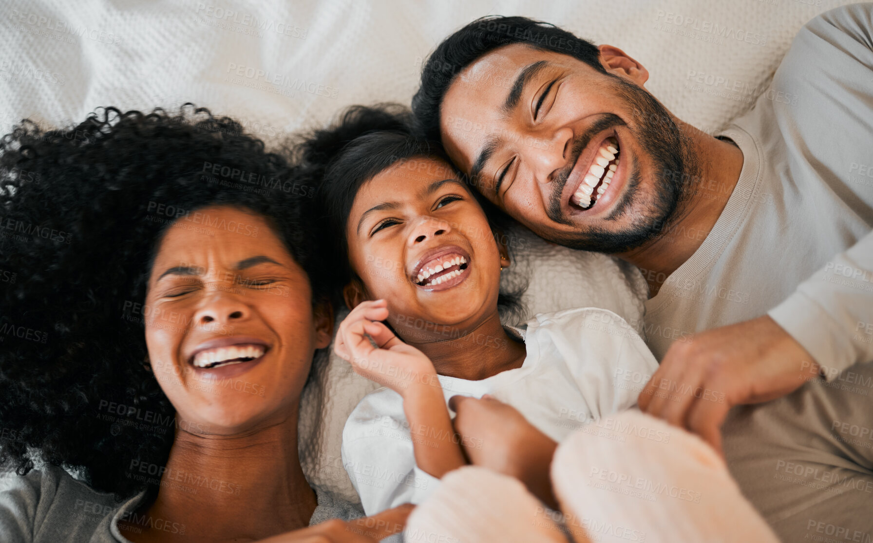 Buy stock photo Top view, home and family with a smile, love and bedroom with weekend break, relax and laughing together. Happy parents, mother or father with child, bed and kid with humor, joke and resting with joy