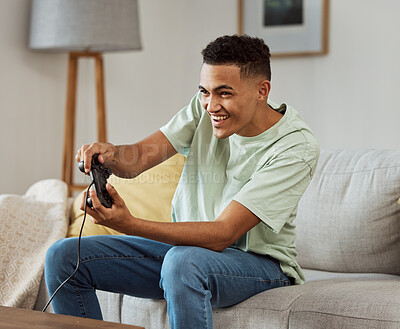 Buy stock photo Happy man, video games and playing on sofa with controller in living room for fun online match at home. Young male person enjoying game time on console for friendly competition or esports in house