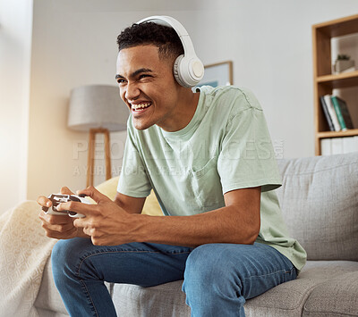 Buy stock photo Home, game controller and man with headphones, smile and relax on a couch, stress relief and internet. Happy person, gamer and guy on a sofa, playing online and headset with audio, sound and esports