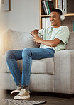Headphones, watching tv and happy man on a living room sofa and relax at home. Series, funny video and laughing with music and listening in a house lounge with web streaming and couch with a smile