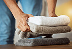 Towel, hands and cleaning service in a home with fabric, cloth and material for washing and bathroom. Laundry pile, person and cleaner with house maintenance, packing and housekeeping with care