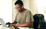 Laptop, serious soldier and black man typing at table in home, planning and remote work. Computer, veteran on internet and technology on desk for freelancer in army, search and reading military email