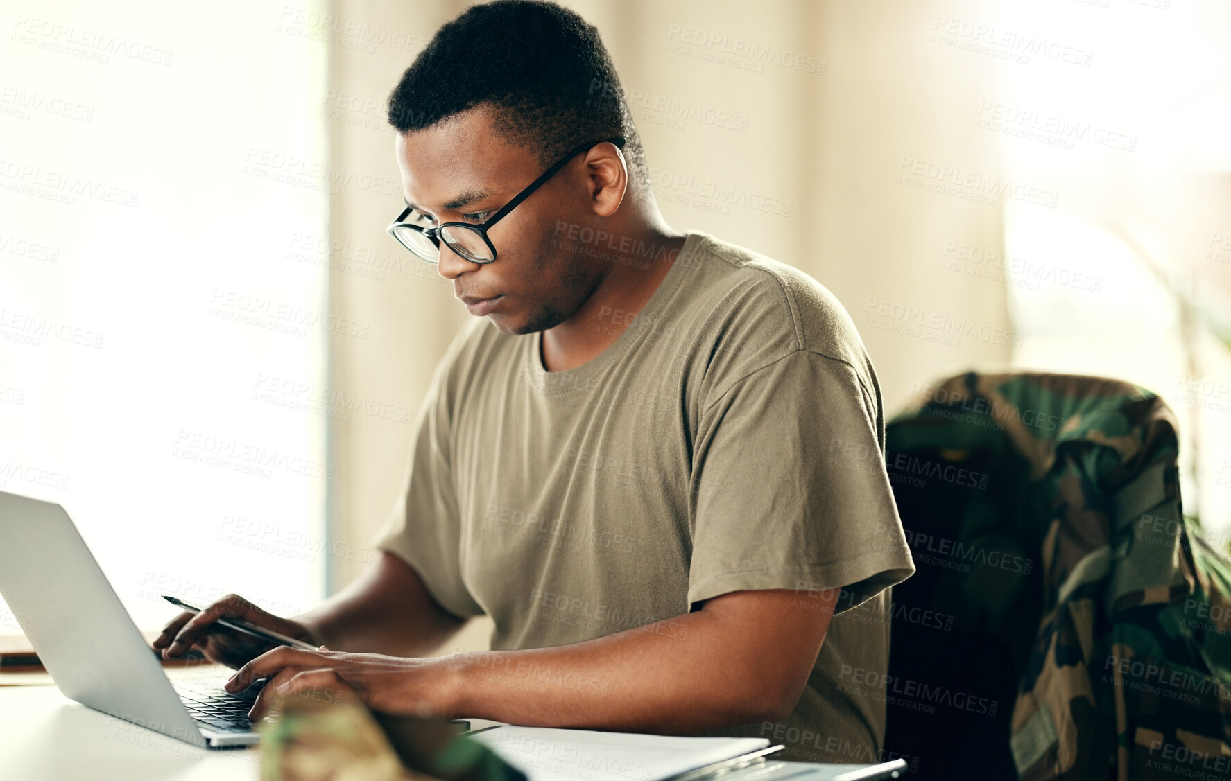 Buy stock photo Laptop, serious soldier and black man typing at table in home, planning and remote work. Computer, veteran on internet and technology on desk for freelancer in army, search and reading military email