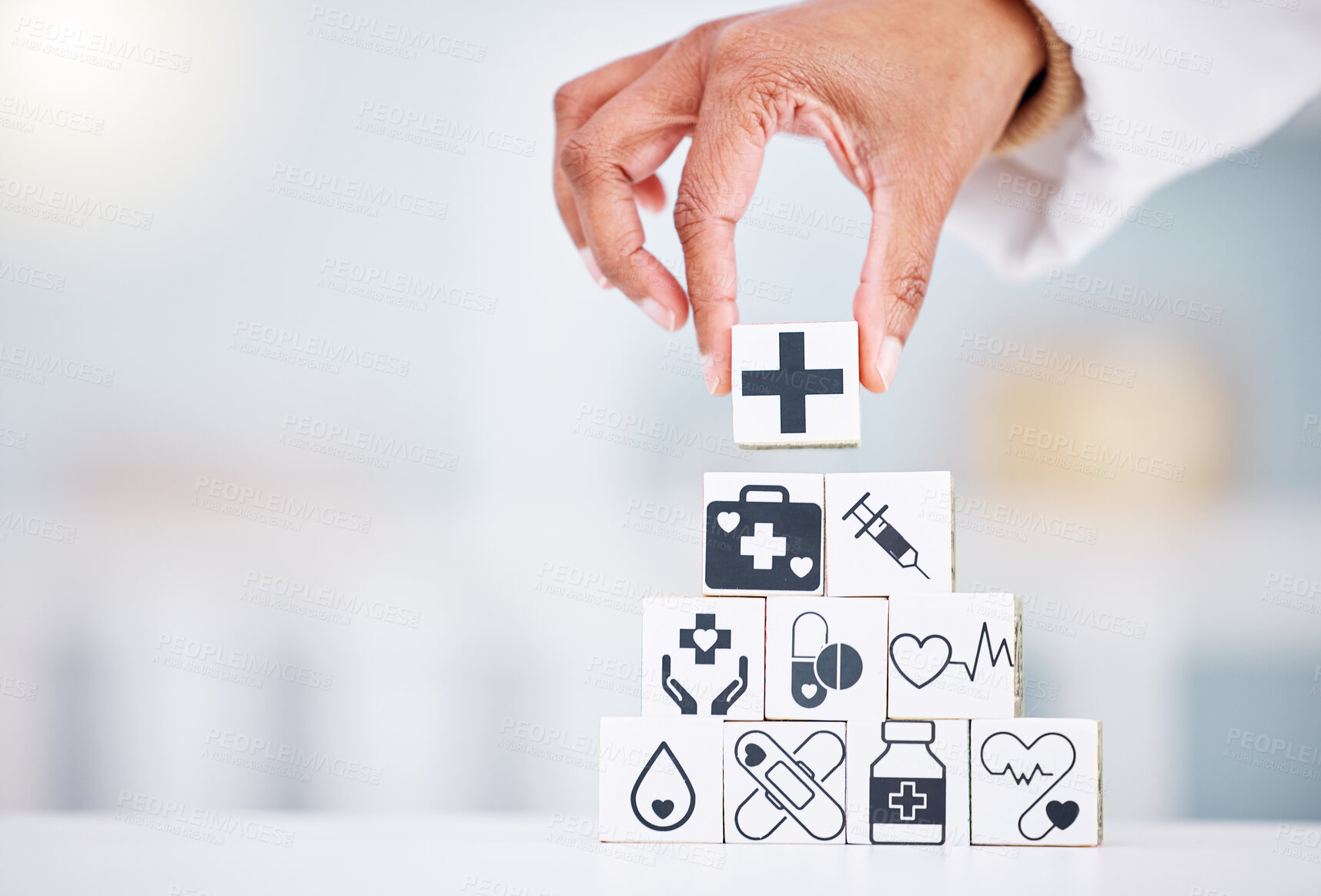Buy stock photo Hands, healthcare and a building blocks tower in a hospital with a doctor closeup for health insurance. Medicine, icon and symbol with a medicine professional in a clinic for cardiology or treatment