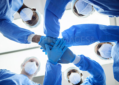 Buy stock photo Doctor, team and hands, surgery and trust in operation theatre together and PPE, partnership and huddle with low angle. Face mask, healthcare and surgeon people, collaboration in hospital and support