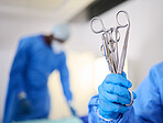 Hand, scissors and a doctor in a hospital or theatre to start operation with surgical tools. Zoom on a surgeon, assistant or staff with sterile equipment for medical procedure or emergency healthcare