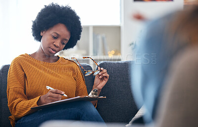 Buy stock photo Therapist on sofa, writing notes with patient, advice and help in psychology, listening and mental health care. Conversation, support and black woman on couch with client, psychologist in counseling.