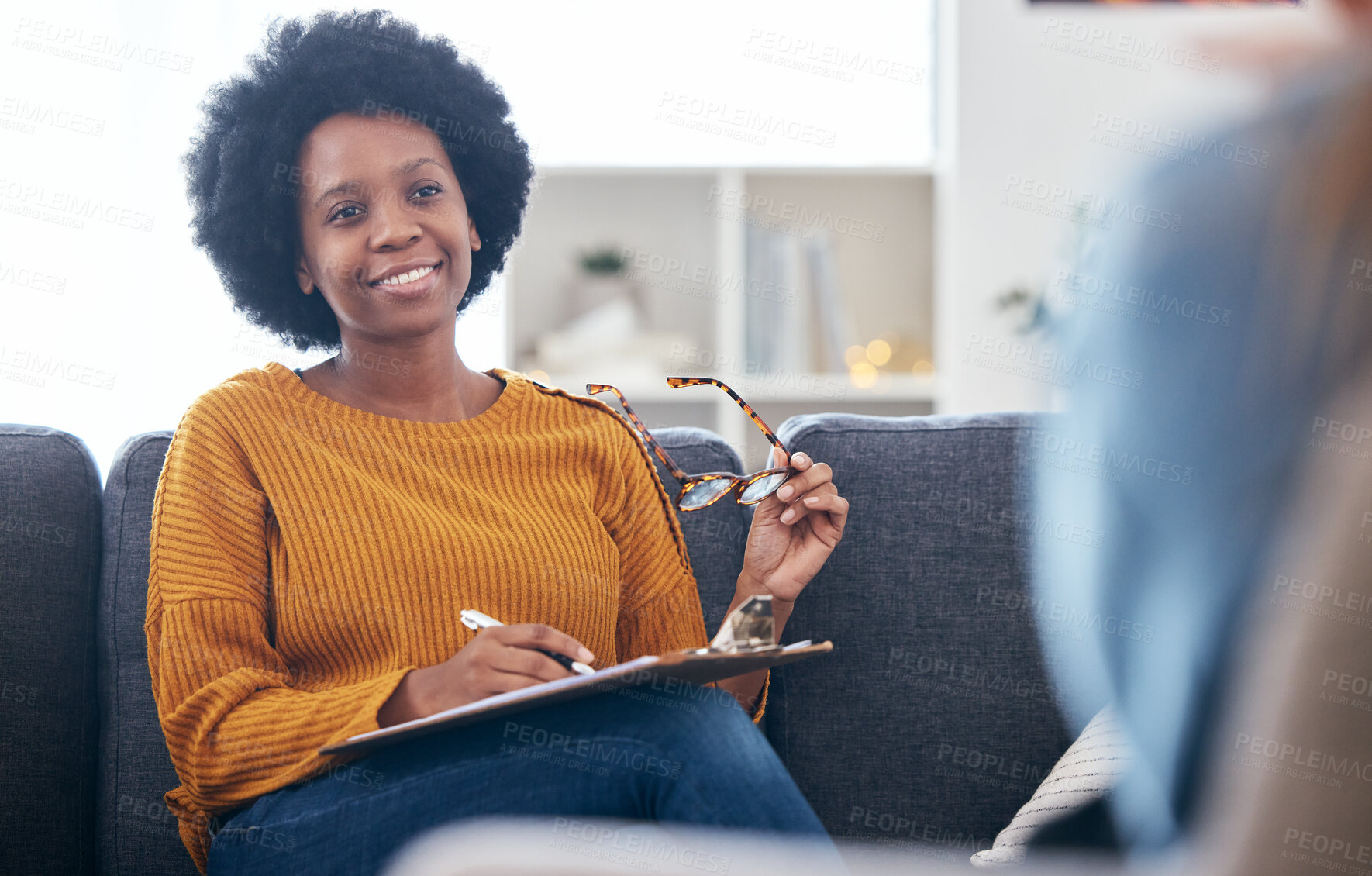 Buy stock photo Psychologist on couch, writing notes with patient, advice and help in psychology, listening and mental health care. Conversation, support and black woman on sofa with client, therapist in counseling.