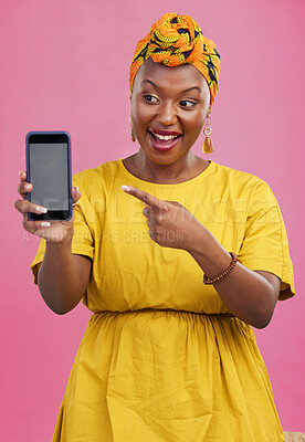 Buy stock photo Happy black woman, phone and pointing to mockup space in advertising against a studio pink background. African female person smile showing technology app, display or screen for deal, discount or sale