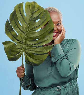 Buy stock photo Black woman, monstera leaf and beauty in portrait, natural cosmetics and fashion on blue background. Silk green dress, eco friendly skincare and dermatology, African model glow and plant in studio 