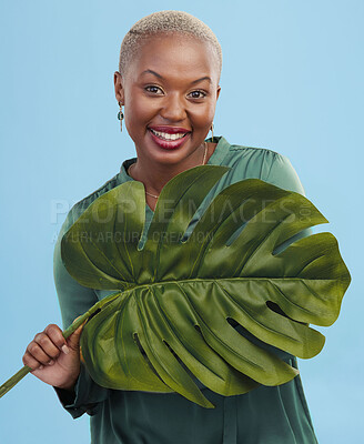 Buy stock photo Black woman, monstera leaf and beauty, face with natural cosmetics and fashion on blue background. Silk green dress, eco friendly skincare and dermatology, African model glow and portrait in studio 