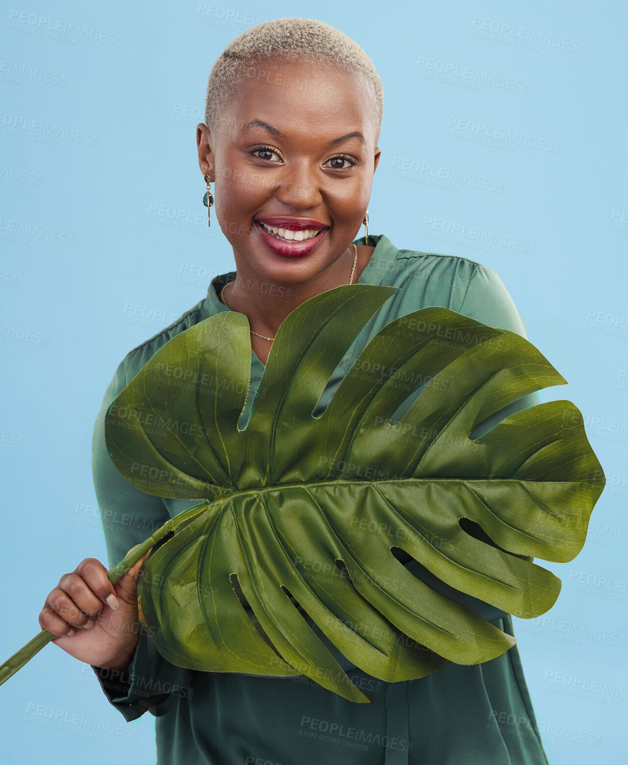 Buy stock photo Black woman, monstera leaf and beauty, face with natural cosmetics and fashion on blue background. Silk green dress, eco friendly skincare and dermatology, African model glow and portrait in studio 