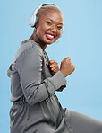 Portrait, dance and happy black woman with music headphones in studio for audio streaming on blue background. Radio, face and African female model smile for podcast earphones, track or playlist 