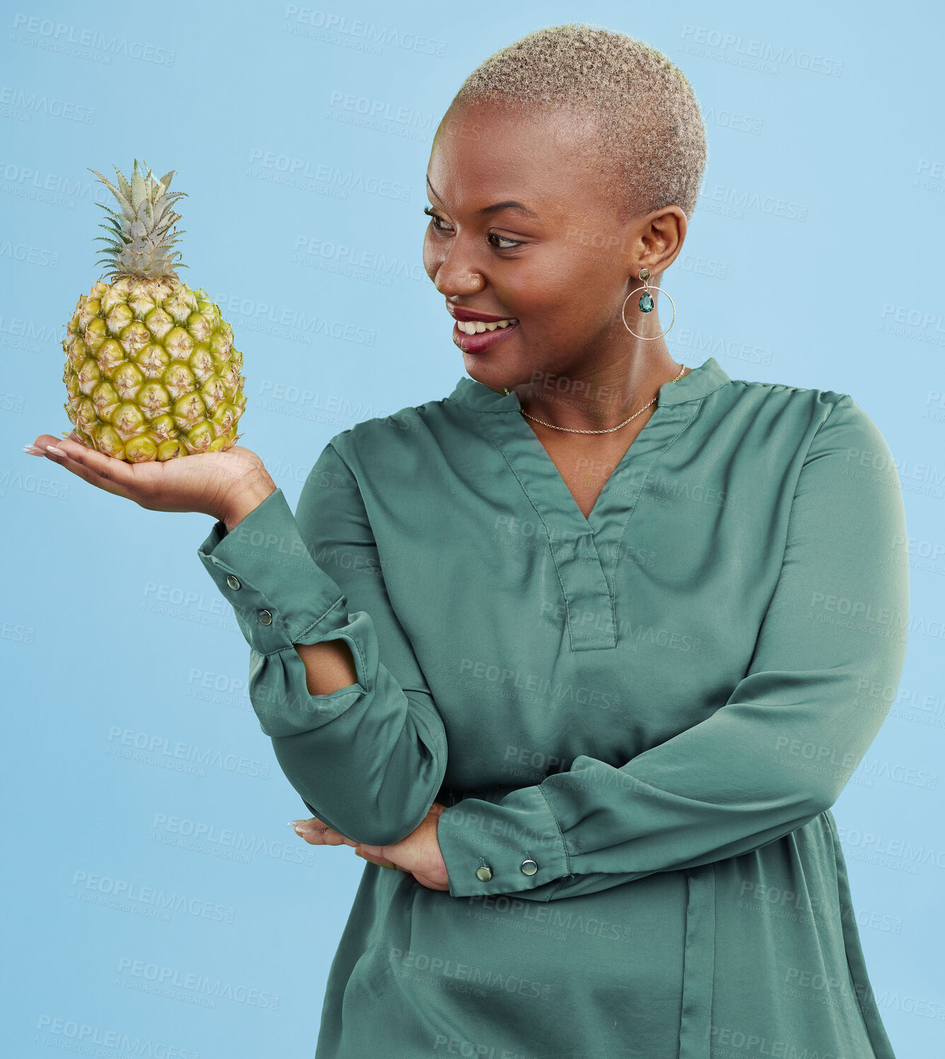 Buy stock photo Smile, pineapple for health or nutrition and a black woman in studio on a blue background for diet. Wellness, fruit or food with a happy young person looking confident for healthy eating or detox