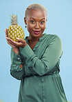 Portrait, pineapple for health or nutrition and a black woman in studio on a blue background for diet. Wellness, fruit or food with a confident young person looking confident for a healthy detox