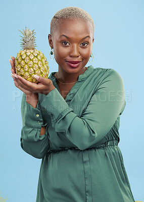 Buy stock photo Portrait, pineapple for health or nutrition and a black woman in studio on a blue background for diet. Wellness, fruit or food with a confident young person looking confident for a healthy detox