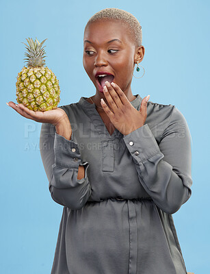 Pineapple, wow and surprise with a health black woman in studio on blue background for diet or nutrition. Wellness, fruit or food with a young person looking shocked by vitamins or minerals benefits