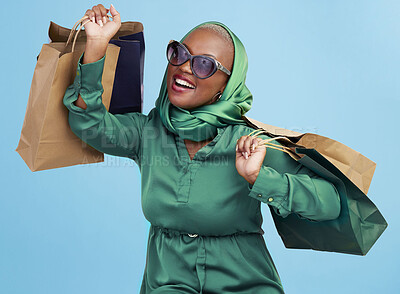 Buy stock photo Shopping bag, studio smile and black woman excited for luxury fashion spree, mall store sales or commerce deal. Retail therapy package, market gift choice and rich African customer on blue background