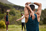 Stretching, fitness and exercise with a man outdoor for health and wellness. Behind runner, athlete or sports person in nature park to start morning run, workout or training with arm muscle warm up