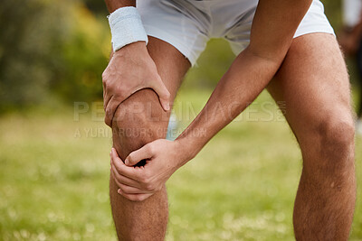 Buy stock photo Hands, knee pain and injury with a sports man closeup outdoor for fitness, training or a workout. Exercise, accident or emergency with an athlete running on a field of grass for a marathon or cardio