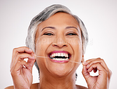 Buy stock photo Senior woman, dental floss and studio portrait for healthcare, beauty and cleaning mouth by white background. Mature female model, teeth whitening and thread for self care, breath and healthy smile