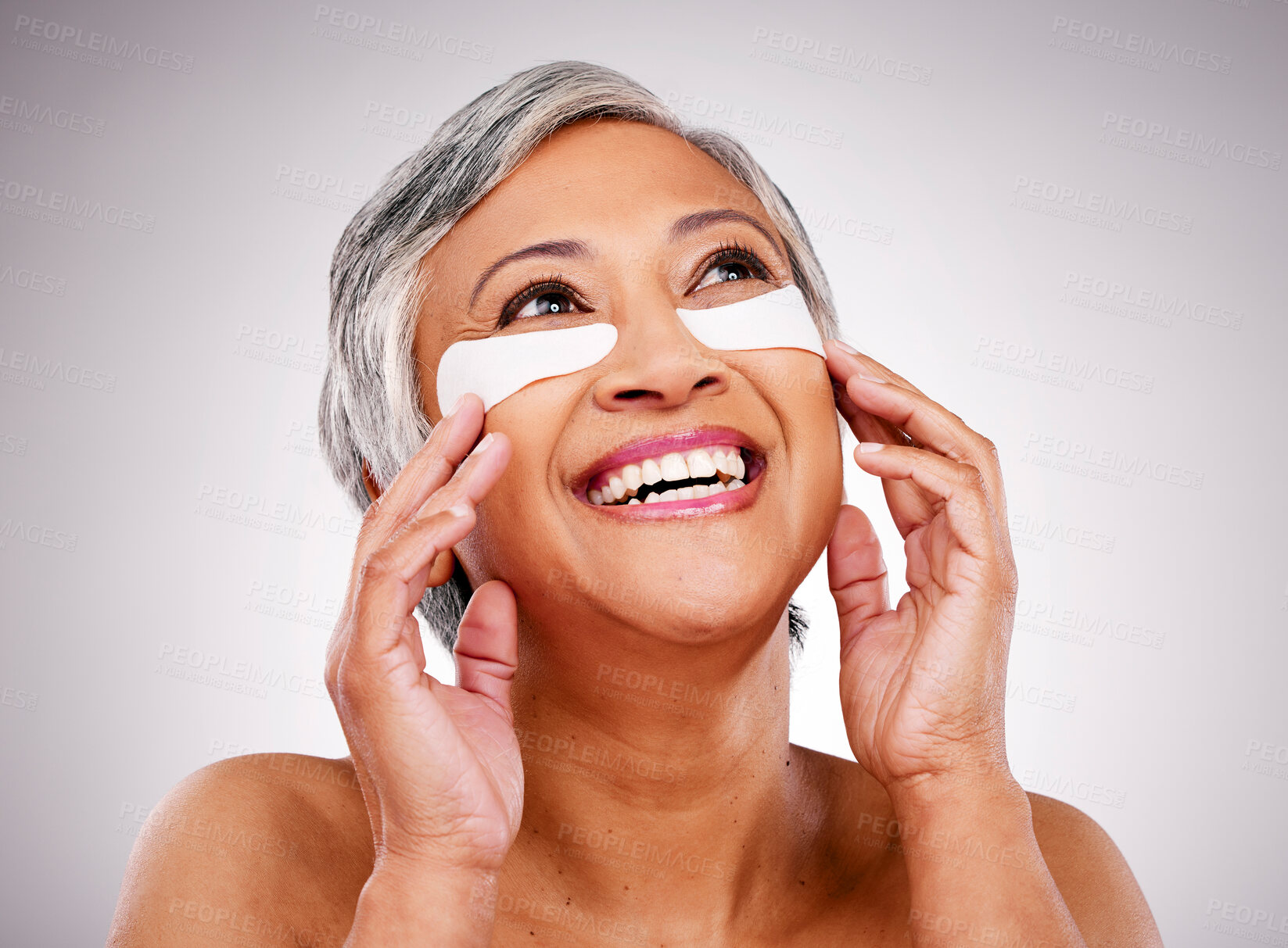 Buy stock photo Senior, happy woman and face with eye patches in skincare, cosmetics or anti aging against a studio background. Mature female person or model smile with pads on eyes for facial treatment or routine