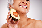 Senior, happy woman and avocado in skincare or natural nutrition against a studio background. Closeup of mature female person or vegan smile with fruit or vegetable in detox, diet or healthy wellness