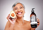 Senior woman, avocado and studio portrait for bottle, product or soap for body wash by white background. Mature female model, fruit and liquid for cleaning, beauty and skincare with organic cosmetics