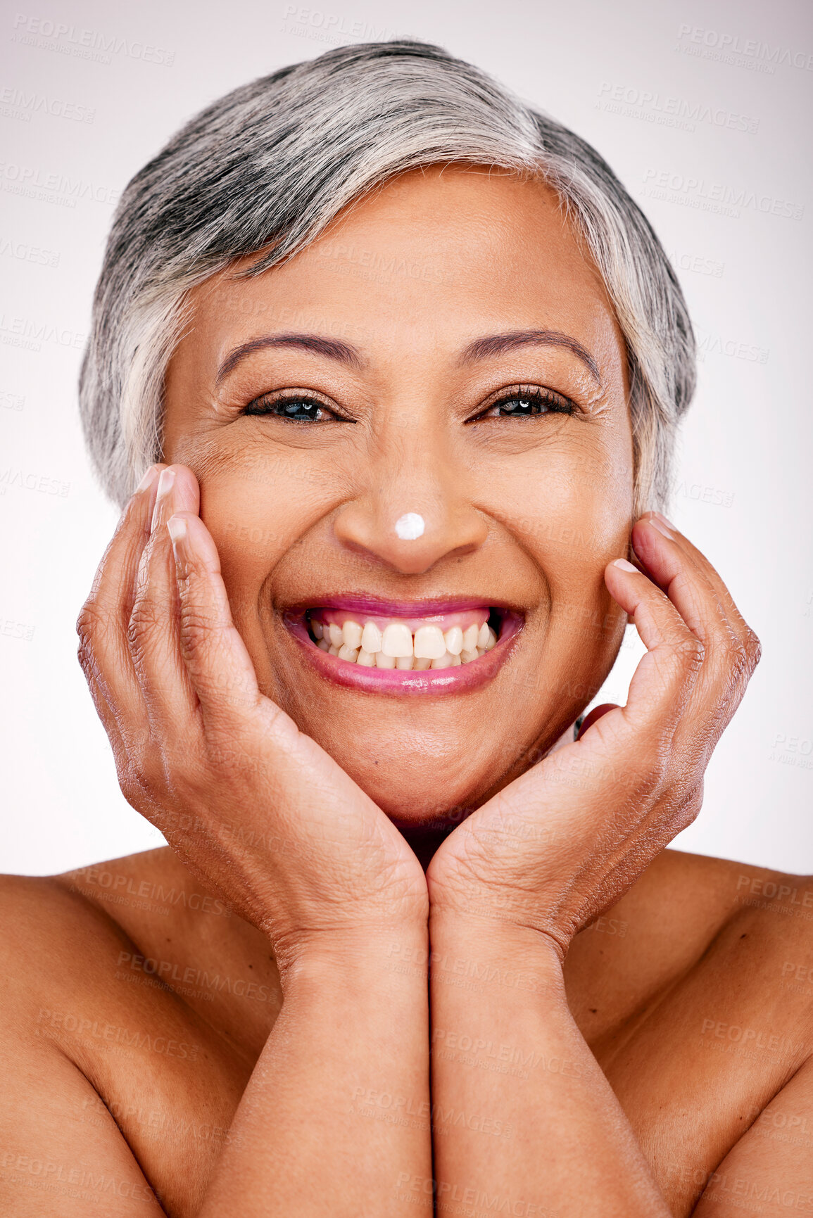 Buy stock photo Senior, happy woman and portrait with face cream in skincare or beauty cosmetics against a studio background. Mature female person smile with lotion, creme or moisturizer for spa or facial treatment