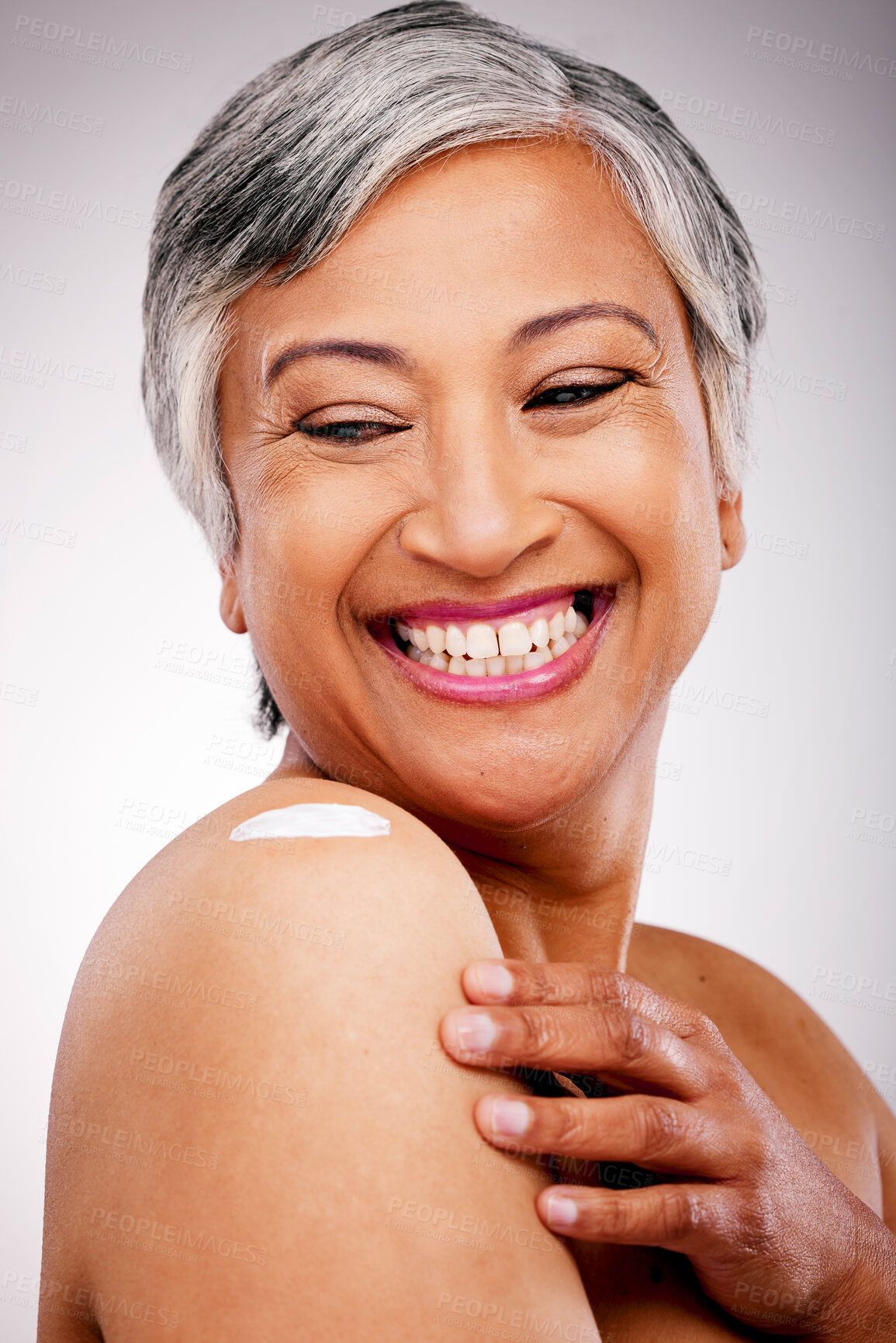 Buy stock photo Body cream, shoulder and beauty of a mature woman with glow and smile on a white background. Dermatology, moisturizer and cosmetics of aesthetic model for skin shine, wellness or self care in studio
