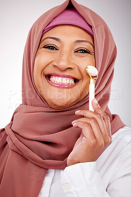 Buy stock photo Facial roller, muslim woman and skin care in studio with quartz for dermatology, cosmetics and glow. Happy mature person portrait with islam hijab, face massage and beauty on a white background