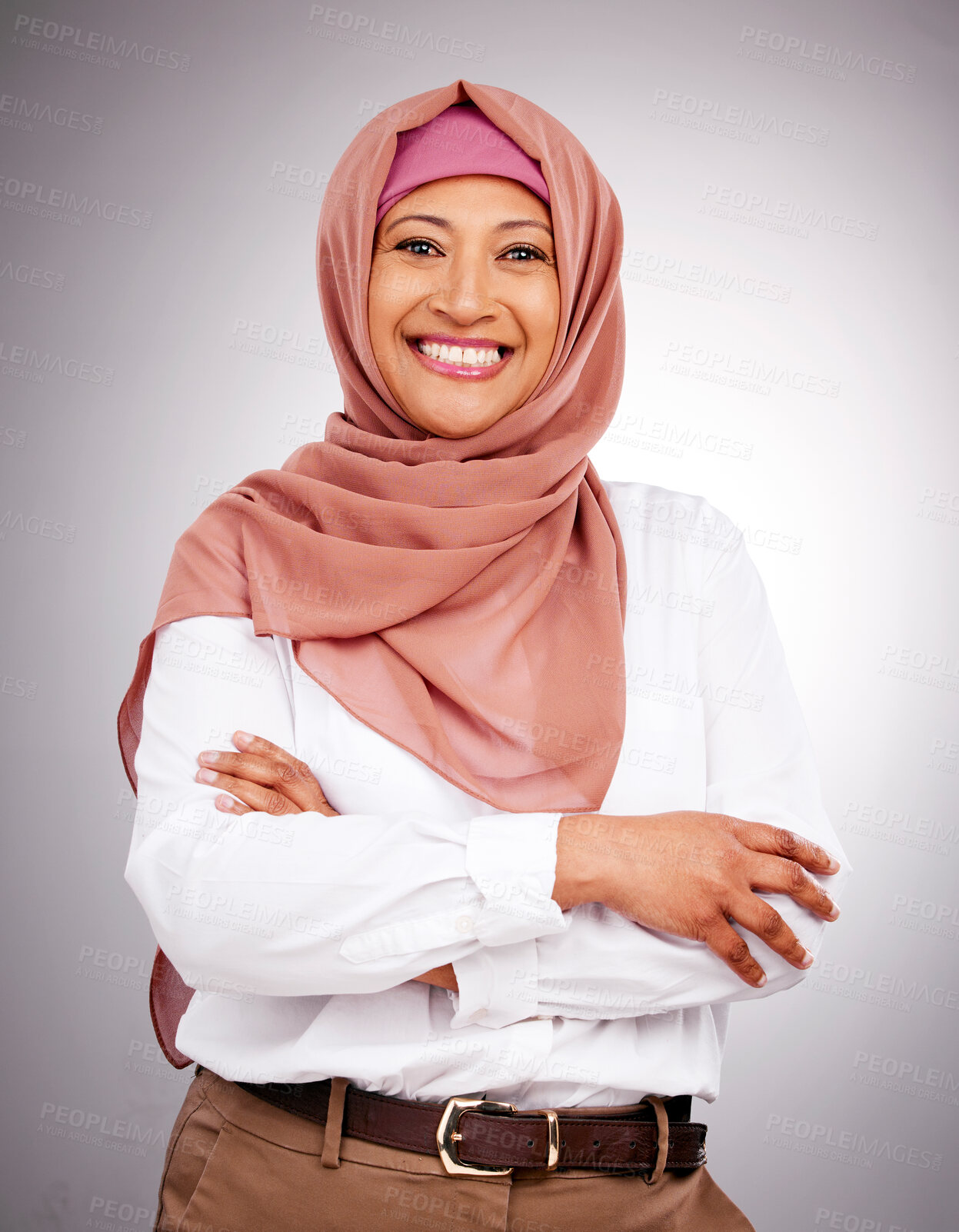 Buy stock photo Portrait, beauty and smile with a muslim woman arms crossed in studio on a gray background. Islam, fashion or culture with a happy mature arab person looking natural or confident in her style