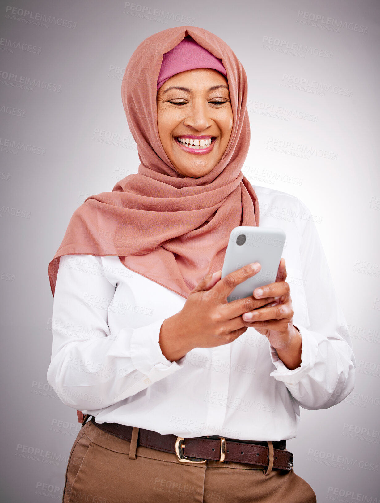 Buy stock photo Muslim, phone and woman with smile in studio for social media scroll, internet post or mobile app on gray background. Smartphone, islam and person with happiness for technology, digital web or joy
 