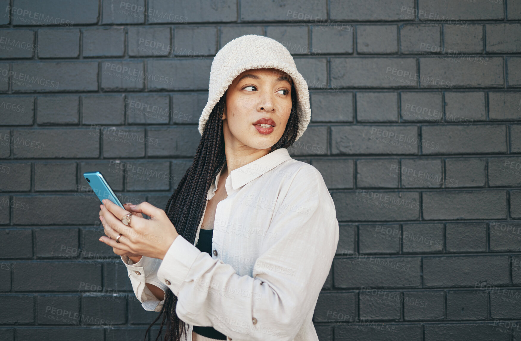 Buy stock photo Woman with phone, brick wall and urban fashion, typing social media post, chat or internet search. Streetwear, gen z girl or online influencer with smartphone for content creation and communication.