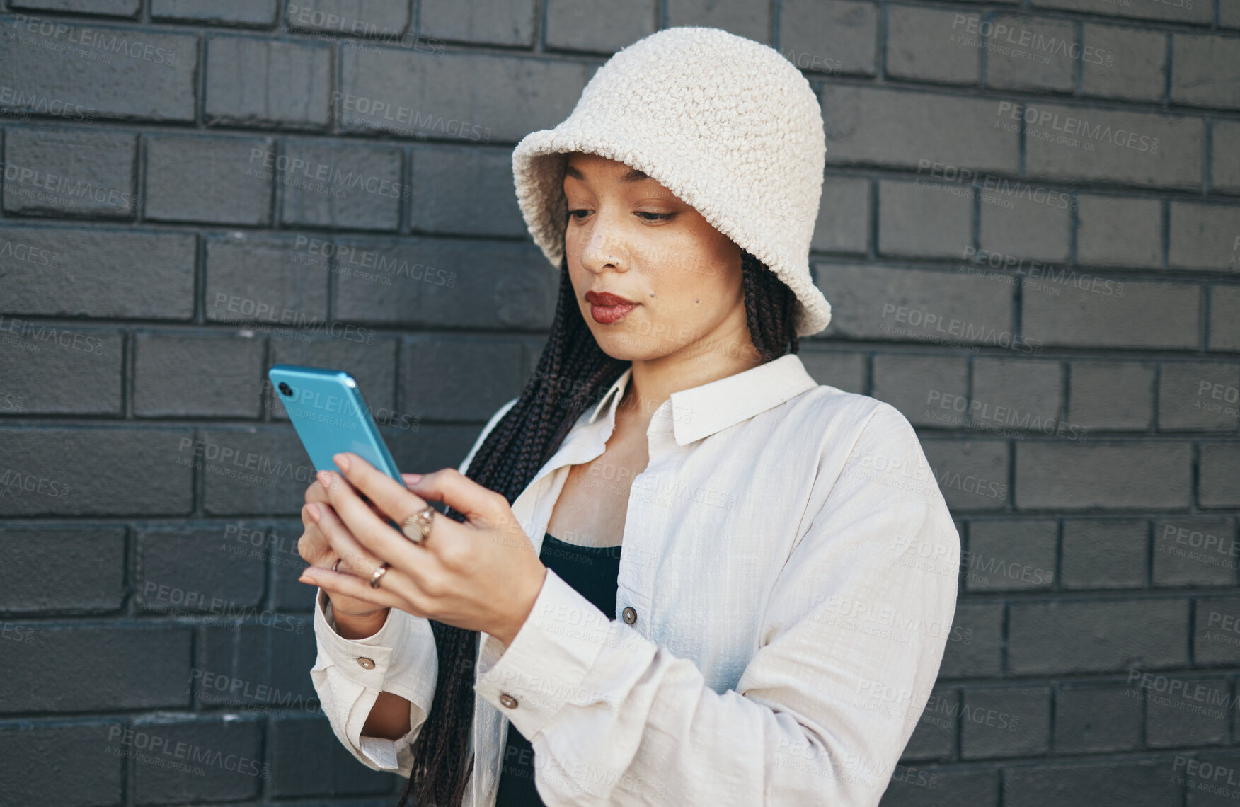 Buy stock photo Girl with phone, brick wall and urban fashion, typing social media post, chat or internet search. Streetwear, gen z woman or online influencer with smartphone for content creation and communication.