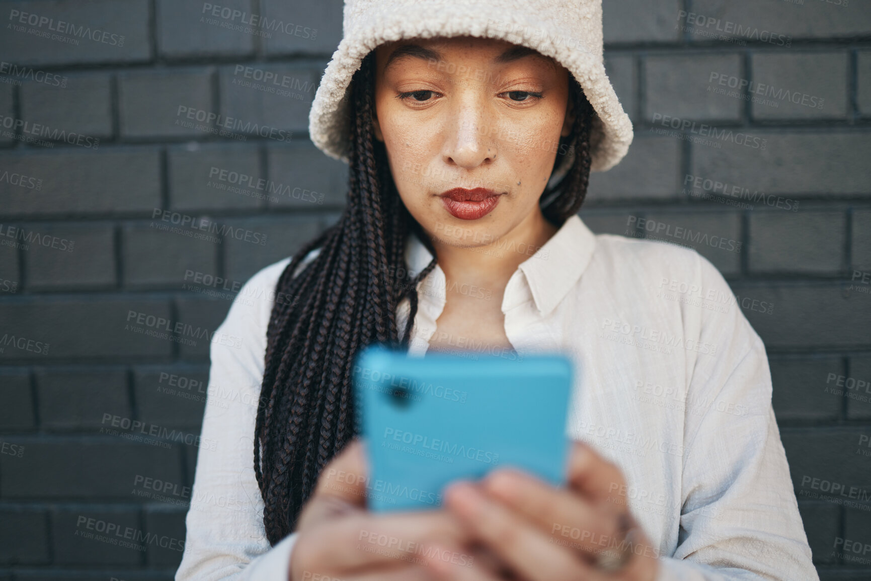 Buy stock photo Girl typing on smartphone, brick wall and urban fashion, for social media chat or or post online. Streetwear, gen z woman or influencer with phone for content creation and communication or technology