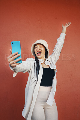 Buy stock photo Selfie, wall and woman with phone in a city for travel, freedom or having fun on orange background. Smartphone, app and lady fashion influencer outdoor on social media, blog podcast content creation