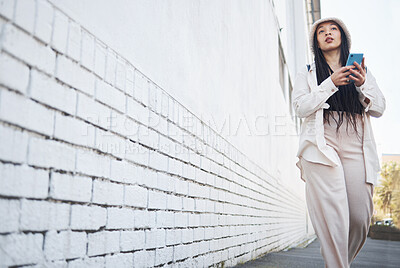 Buy stock photo Woman on street with phone, brick wall and walking in city for travel holiday blog on social media. Influencer, streamer or gen z girl on sidewalk with urban fashion, smartphone and  content creation