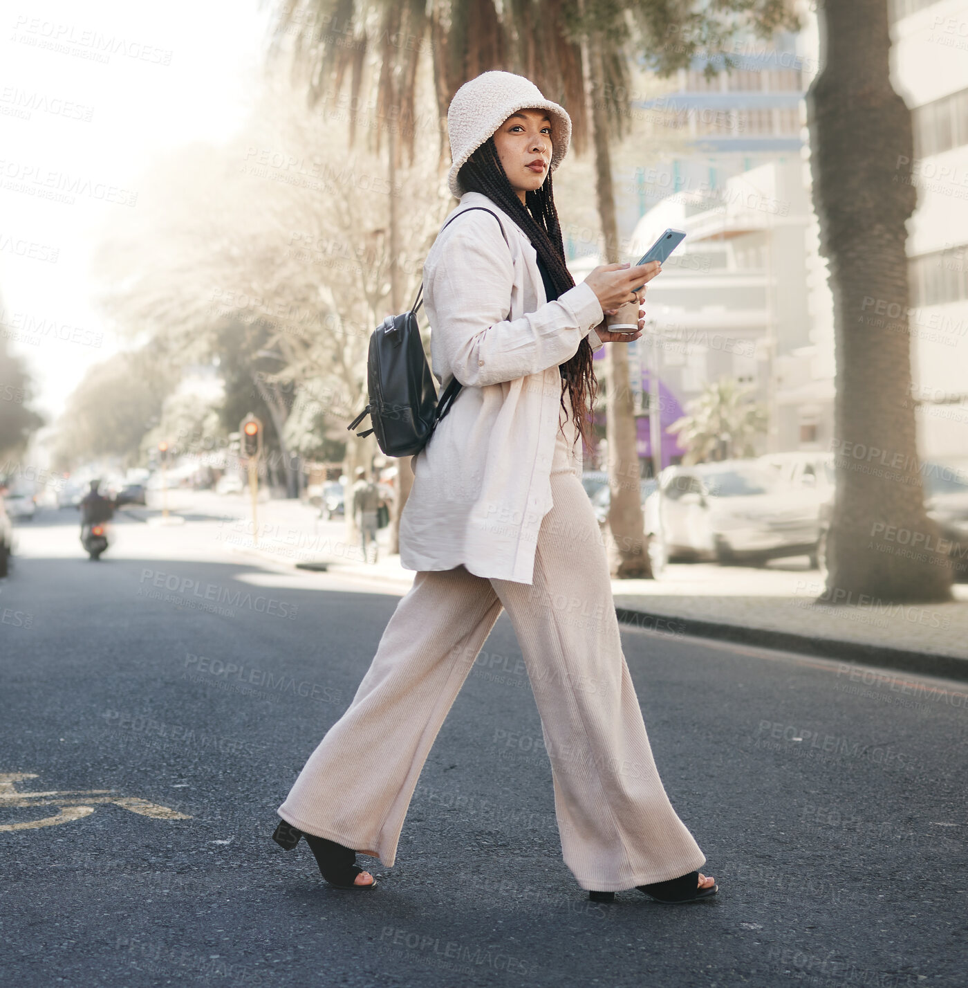 Buy stock photo Woman crossing street with phone, walking in city and travel with location app, social media and streetwear. Influencer, streamer or gen z girl with urban fashion, smartphone and direction in road.