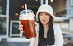 Woman hand, smoothie and closeup outdoor at a restaurant and drink from cafe. Milkshake, coffee shop and gen z fashion of a female person with a straw on break on diner patio with blurred background