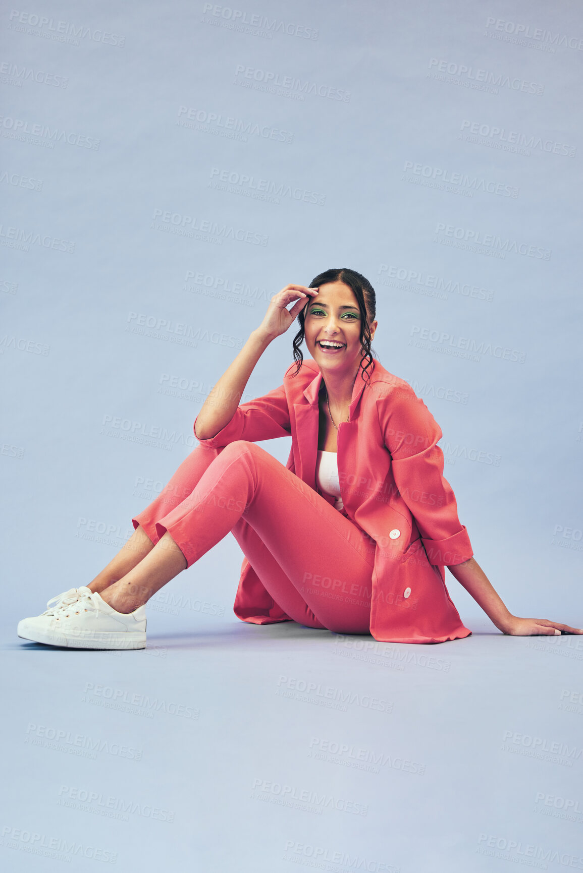 Buy stock photo Portrait, woman and sitting on floor in studio with happiness and makeup for beauty, aesthetic and cosmetics with mockup space. Smile, person and creative clothes on purple background for fashion 
