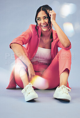 Buy stock photo Woman, fashion and thinking with gen z style and smile and sitting in studio. Trendy, stylish clothing  and happy female person with freedom, funky outfit and modern clothes with blue background