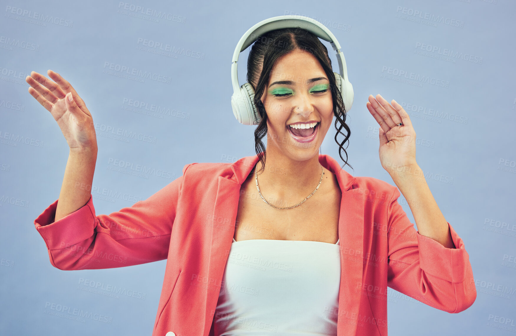 Buy stock photo Dance, smile and woman with headphones, celebration and makeup on a blue studio background. Person, girl and model with headset, energy and streaming music with happiness, audio and song with sound