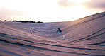 Hill, sand or athlete on motorcycle for adventure, action or fitness with wellness in outdoor workout. Sunset, desert or sports driver on motorbike on dunes in training, exercise or race challenge 