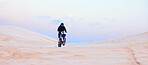 Rally, desert or athlete driving motorcycle for action, adventure or fitness with performance or adrenaline. Sand, sports or person on motorbike on dunes for training, exercise or race or challenge