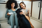 Friends, dog and happy morning in kitchen, home or women with coffee, drink and eating breakfast on the floor of apartment. Couple, animal or pet in house with love, care and support from girls