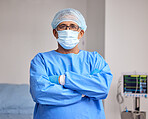 Surgeon, portrait and man with arms crossed in hospital with confidence in emergency healthcare, medicine or cardiology. Doctor, face mask and pride in surgery, work and operating room or theater