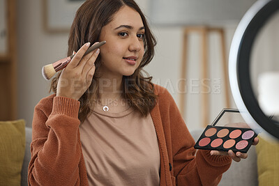 Buy stock photo Streaming, makeup and tutorial with a woman influencer in her home to broadcast live content to viewers. Social media, product or review with a young brand ambassador in the living room for cosmetics